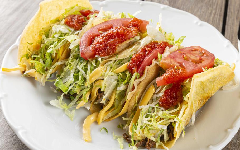 Four tacos on a plate.